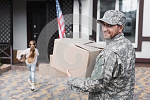 Military serviceman holding cardboard box and