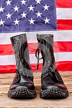 Military soldier boots against american flag background.