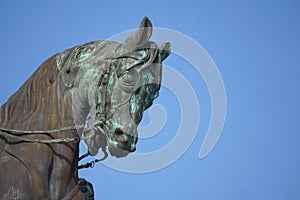 Military statue of horses head against blue sky