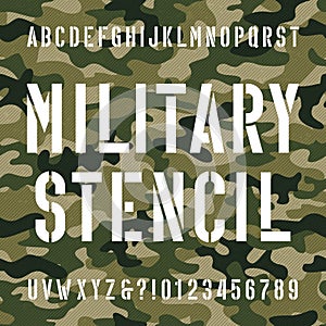 Military stencil alphabet font. Type letters and numbers on distressed camo seamless background. photo