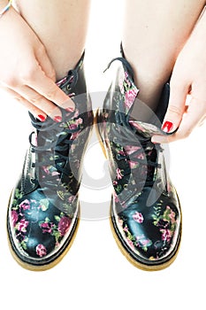 Military style boots with flowers decoration on an hands with po