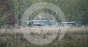 Military tank moving in a field