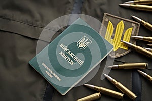 Military token or army ID ticket lies on green ukrainian military uniform