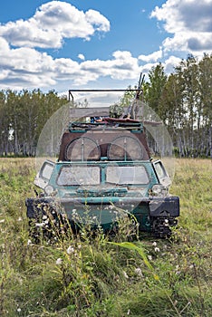 A military tracked tractor built in the 70s in the Soviet Union on a hunting trip in the autumn forest