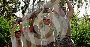 Military troops carrying heavy wooden log during obstacle course 4k