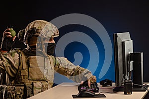 Military in uniform sitting at a computer are cyberwar, playing, throwing a grenade