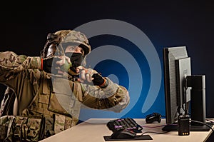 Military in uniform sitting at a computer are cyberwar, playing, throwing a grenade