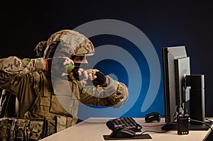 Military in uniform sitting at a computer are cyberwar, playing, throwing a grenade
