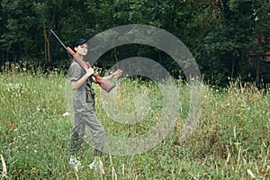 Military woman Hunting in the field with a weapon on his shoulder black cap