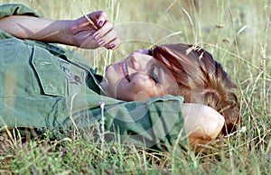 Military woman lying on grass