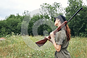 Military woman Shotgun on shoulders fresh air hunting green overalls