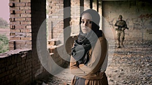 Military, young muslim woman standing in abandoned building, soldier walking towards woman with scared and sad