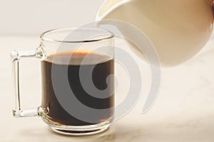 Milk is added to coffee glass/milk is added to coffee glass on w