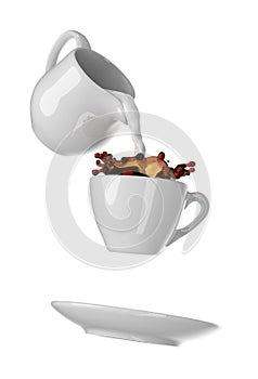 Milk being poured into small cup of coffee. Isolated white background