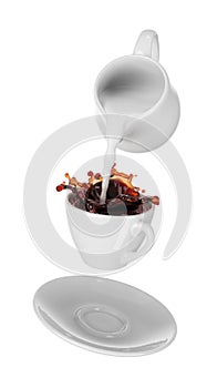 Milk being poured into small cup of coffee. white background