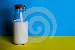 Milk in a bottle, blue and yellow background. a place to copy.