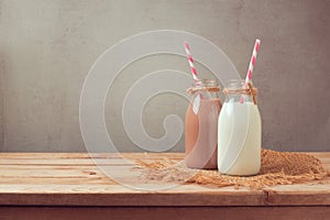 Milk bottle and chocolate milk bottle on wooden table. Healthy eating