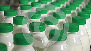 Milk in bottles moving on conveyor. Milk with green caps on a conveyor belt at a dairy factory.