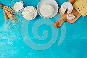 Milk and cheese, dairy products on wooden blue background. Jewish holiday Shavuot concept.