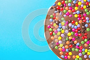 Milk Chocolate Birthday Cake with Multicolored Glazed Candy Sprinkles. Party Celebration Kids Fun Cheerful Mood. Blue Background