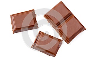 Milk chocolate pieces isolated on white background. top view