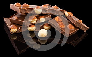 Milk chocolate pieces with nuts on a dark background