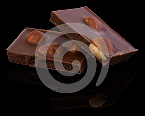 Milk chocolate pieces with nuts on a dark background