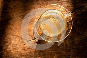 milk coffee in a coffee cup on a beautiful vintage dark old wooden table background texture top view