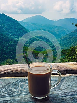 Milk coffee in glass mug with mountain scene