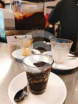 Milk coffee with ice cream with two empty cups on the table