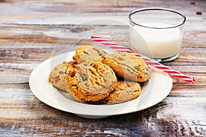 Milk and cookies for Santa Claus and Santa`s hat over wooden bac