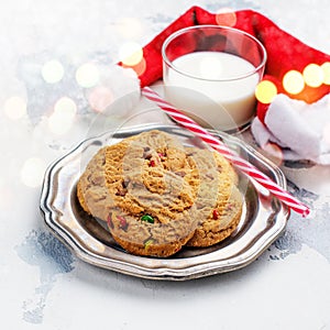 Milk and cookies for Santa Claus and Santa`s hat over wooden bac