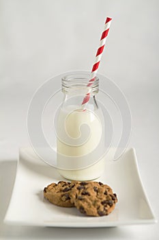 Milk and cookies white background with red striped straw