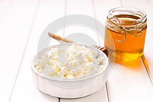 Milk cottage cheese with honey on white wooden table. Selective focus image. Copyspace for your text.