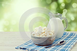 Milk and cottage cheese over green bokeh background. Jewish holiday Shavuot concept