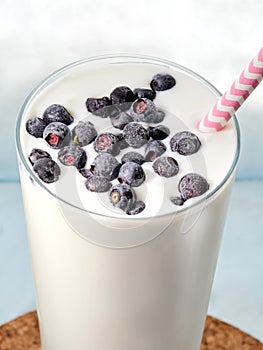 Milk drink with blueberries, in a transparent glass