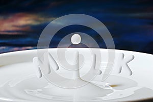 Milk drop or droplet dripping into a bowl full with letters added to make