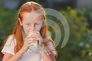 Milk is fresh from the cow - beautiful girl with dairy products. Healthy baby milk - Portrait beautiful redhead girl drinking fres