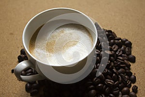 Milk froth in coffee mugs and coffee beans photo