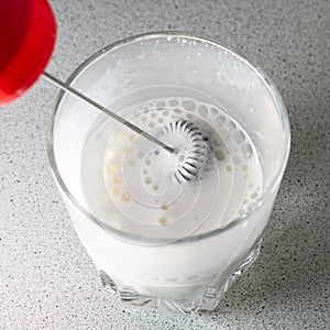 milk frother. frothed milk in a glass