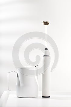 Milk frother and white pitcher photo