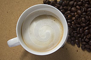 Milk froth in coffee mugs and coffee beans photo