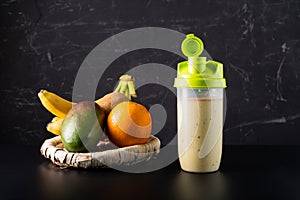 Milk fruit cocktail on a black background. Cocktail in a shaker.