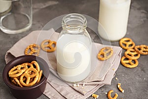 Milk in glass and bottle with cookie on grey table, close-up