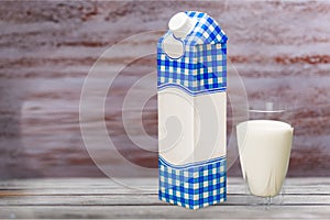 Milk in glass and box on wooden table