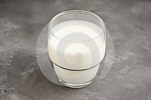 Milk in glass on the grey background. Close-up