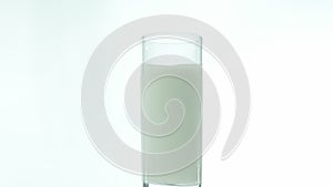 Milk in a glass is isolated on a white background, a natural dairy product in a transparent glass is spinning on a white backgroun