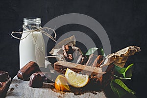 Milk in glass jar with orange and chocolate sweets.