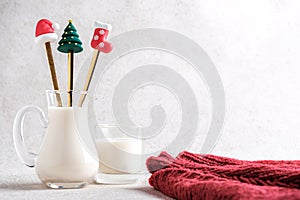 Milk in a glass jug with Christmas-themed straw and Red Coat