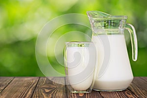 Milk in glass and jug on table